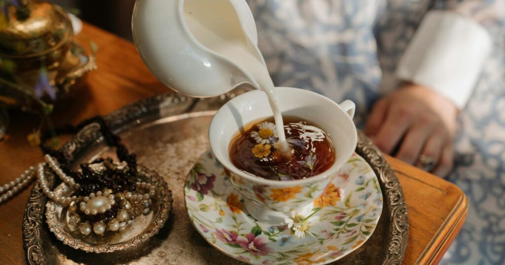 Drinks to Help You Sleep better,
A steaming cup of chamomile tea with a delicate floral aroma, surrounded by dried chamomile flowers on a wooden table.
