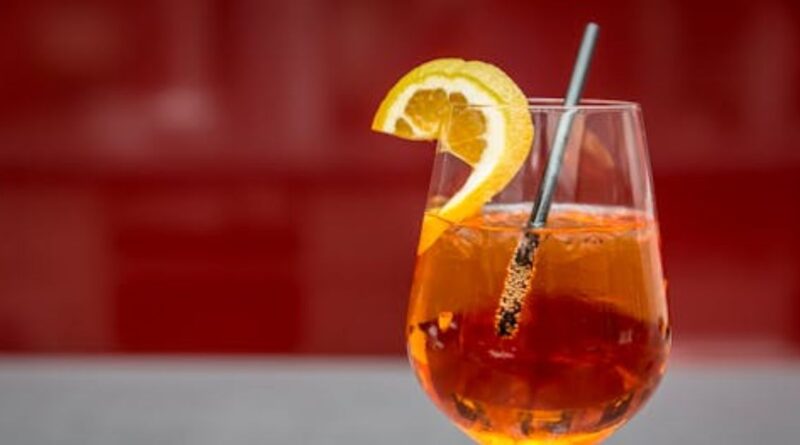 A glass of orange drink garnished with a lemon wedge, featured in the Angostura Bitters Recipe guide.