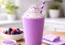 purple smoothie topped with whipped cream and fresh berries, featured in the Grimace Shake Recipe.
