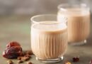 Two glasses of milk surrounded by dates and nuts, illustrating ingredients for a banana date smoothie recipe.
