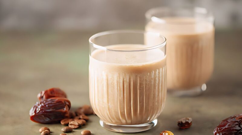 Two glasses of milk surrounded by dates and nuts, illustrating ingredients for a banana date smoothie recipe.