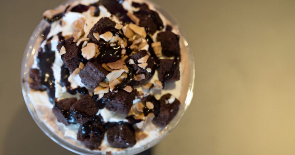  A creamy chocolate milkshake with whipped cream and nuts, named Blissful Darkness.