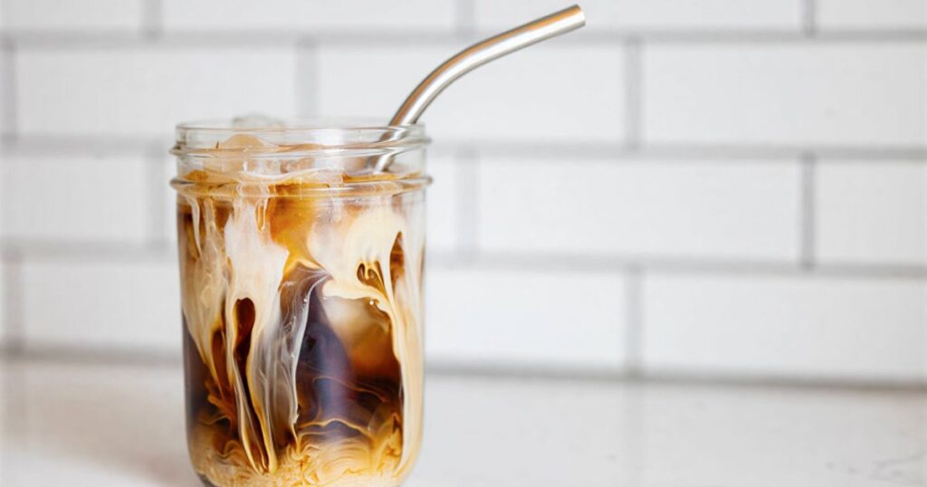 A glass jar filled with cold brew coffee and ice, highlighting the refreshing benefits of this popular beverage.